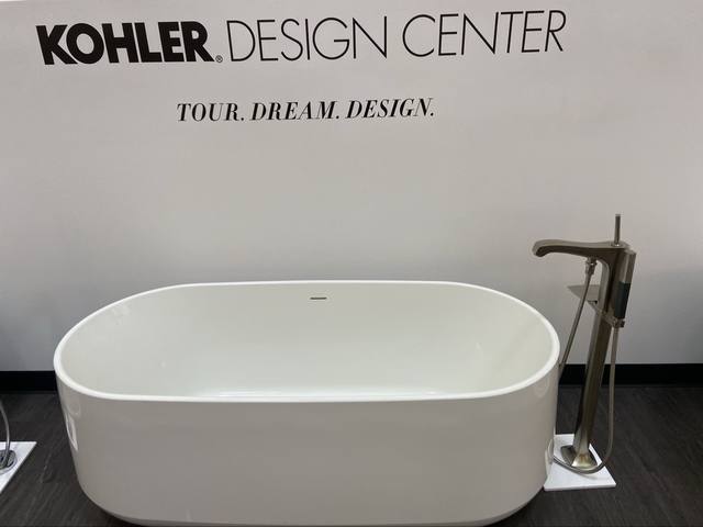 freestanding Kohler tub under "KOHLER DESIGN CENTER / TOUR. DREAM. DESIGN." wall