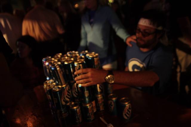 four angles of the Miller Lite can pyramid being built on the bar table