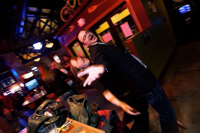 couple posing in the bar (bike mounted on the wall, arcade games