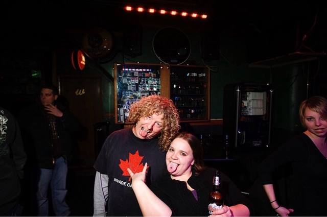 Mike in a bar, tongues out, "INVADE CANADA" shirt
