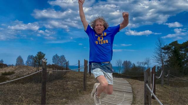 Mike mid-jump on the dunes boardwalk, Lake Michigan behind