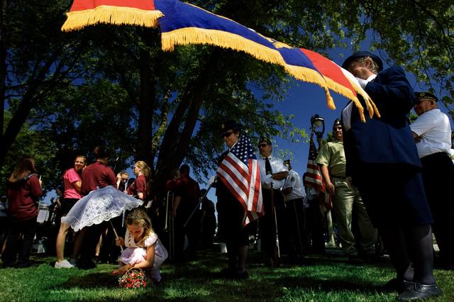 veterans' ceremony, big fringed flag, color guard, little girl with a lace parasol