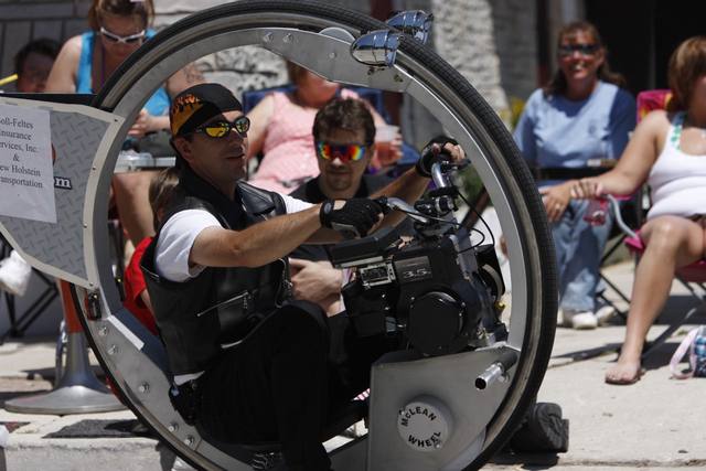 man riding the "McLean Wheel" motorized monowheel in the parade