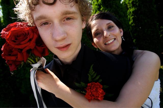 prom couple with red roses, boutonniere