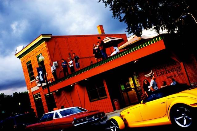 rooftop party at National Exchange Bank & Trust, yellow Plymouth Prowler, red car (race-weekend street scene, Elkhart Lake area