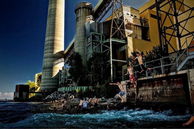 Kids jumping off the industrial waterfront into the lake