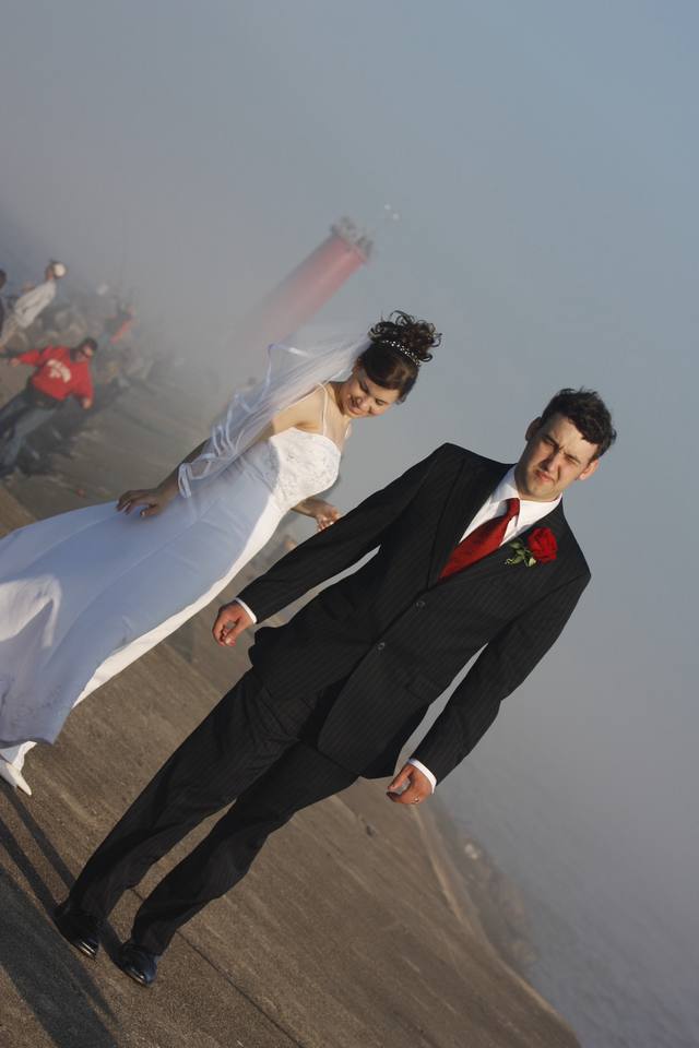 Walking the pier in the lake fog, lighthouse looming